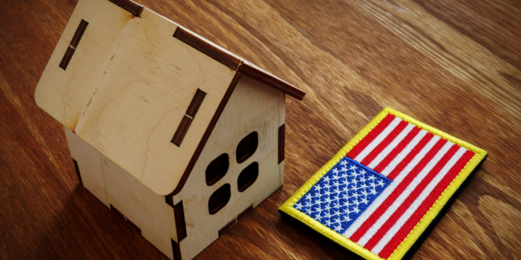 A small wooden house model next to an American flag patch.